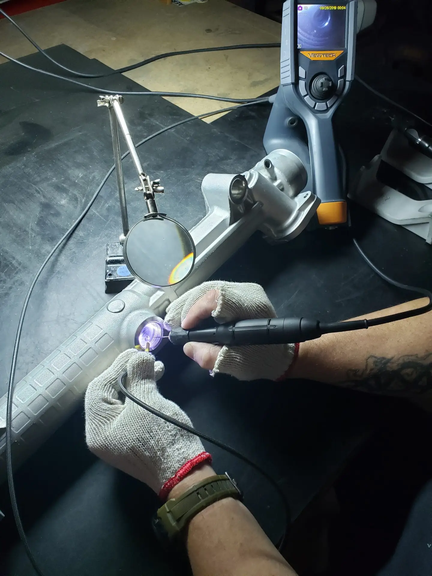 Technician using a handheld inspection tool to examine a metal component